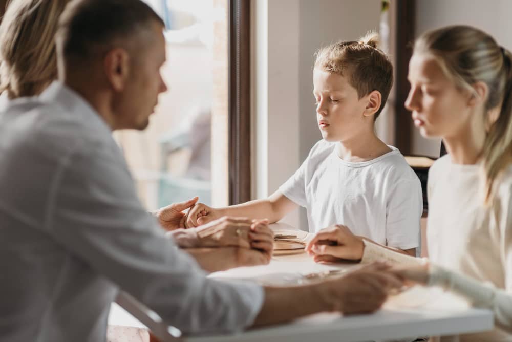 Parents and two children discussing family matters at a table