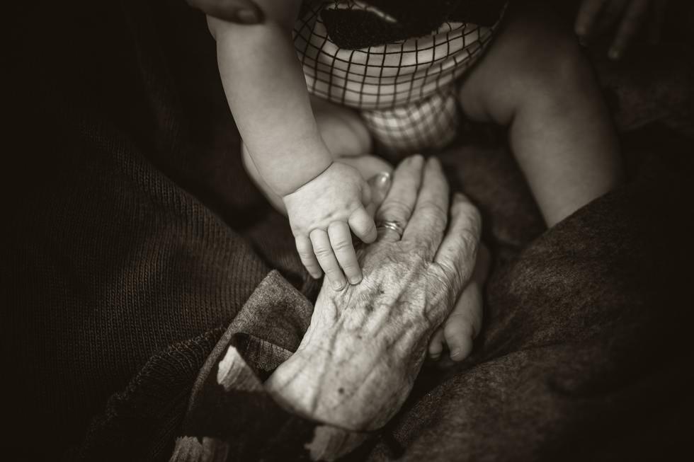 Elderly hands holding a child's hands