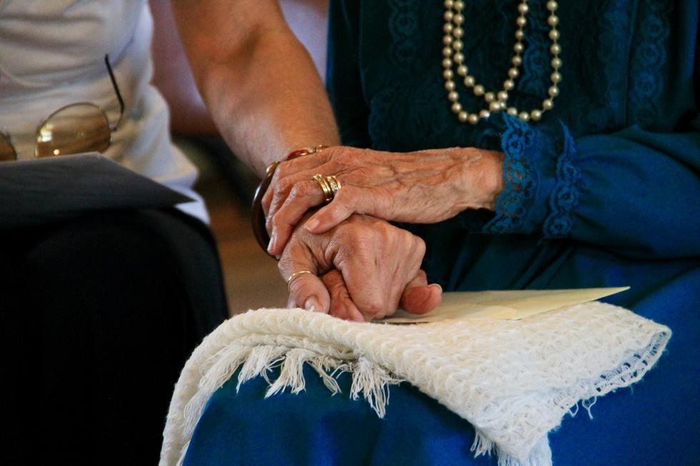 Old Couple Holding Hands Sitting Up Color