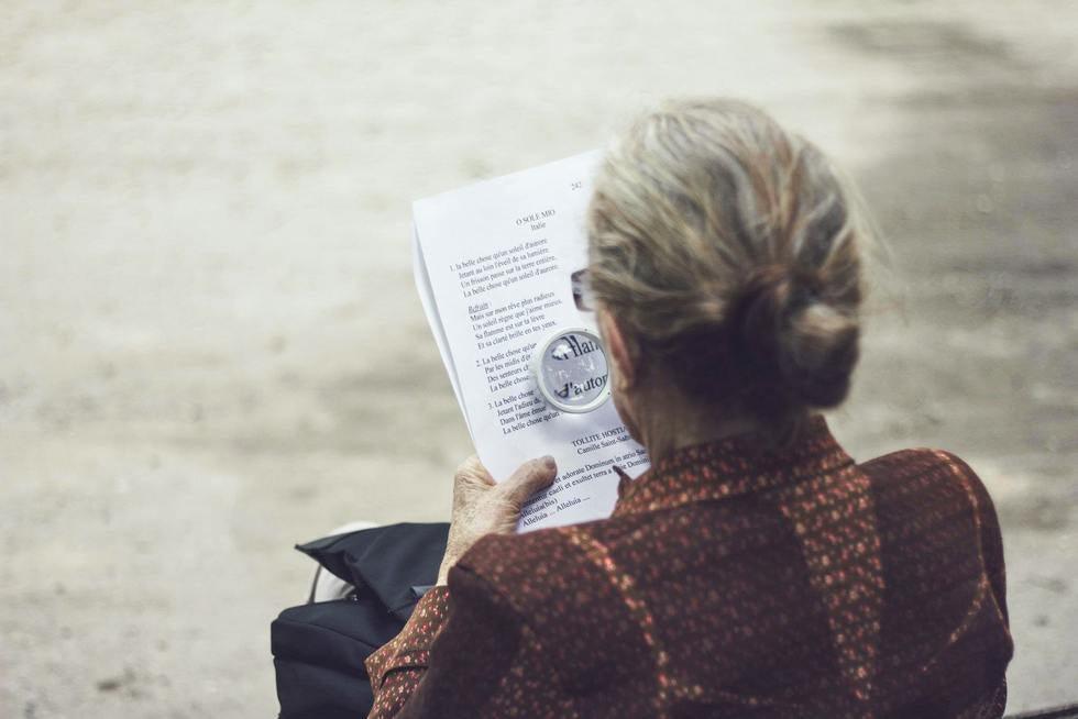 Older Woman Reading With Maginfying Glass