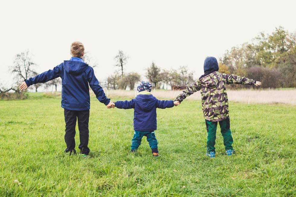 Three Kids Holding Hands Back To Camera